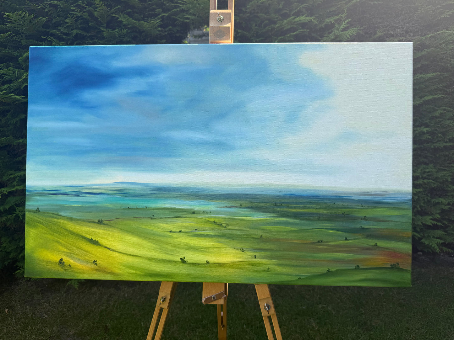Breathe original oil landscape painting of rolling green hills under a dramatic blue and white sky by Caroline Manson