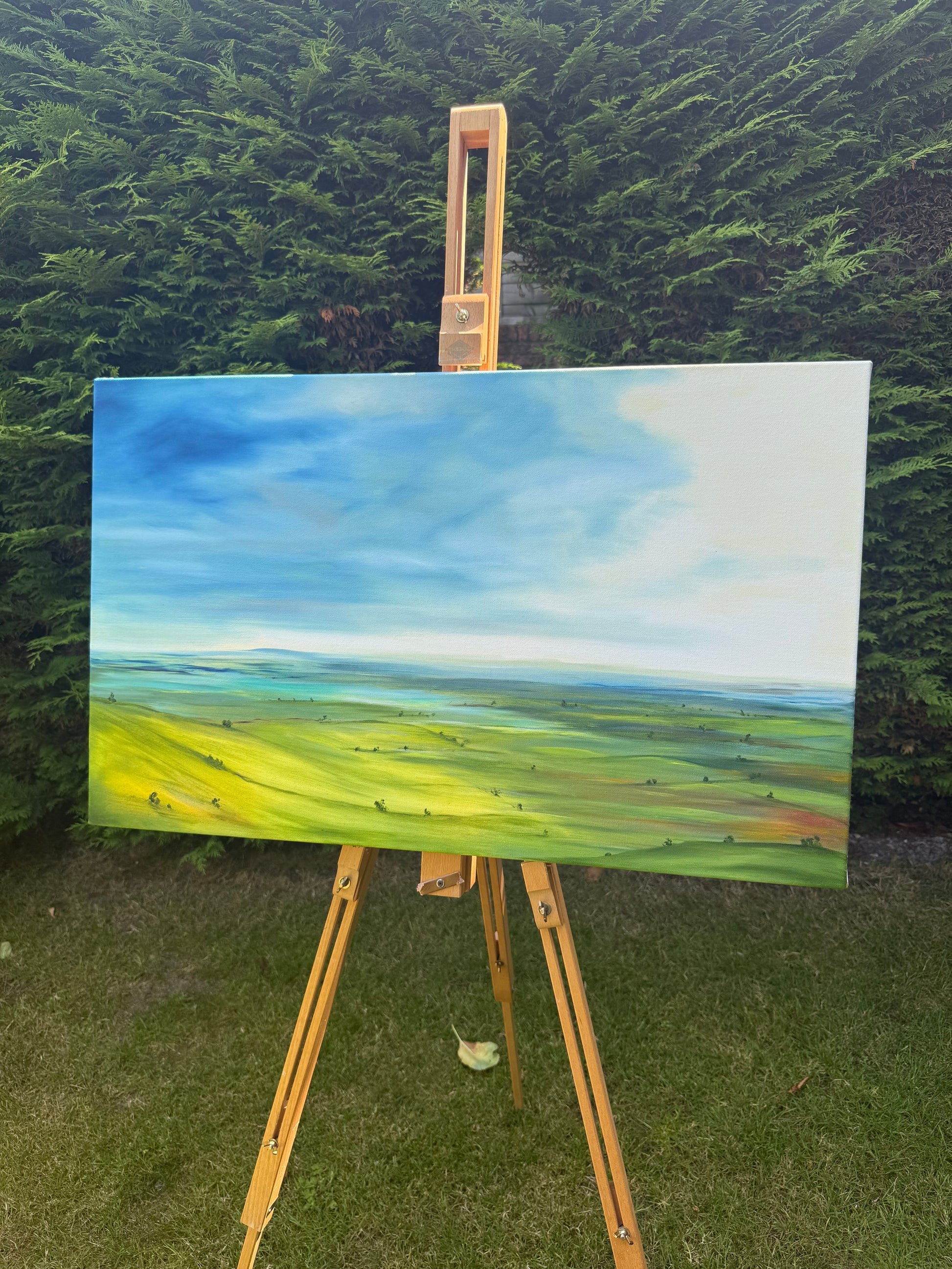 Breathe original oil landscape painting of rolling green hills under a dramatic blue and white sky by Caroline Manson