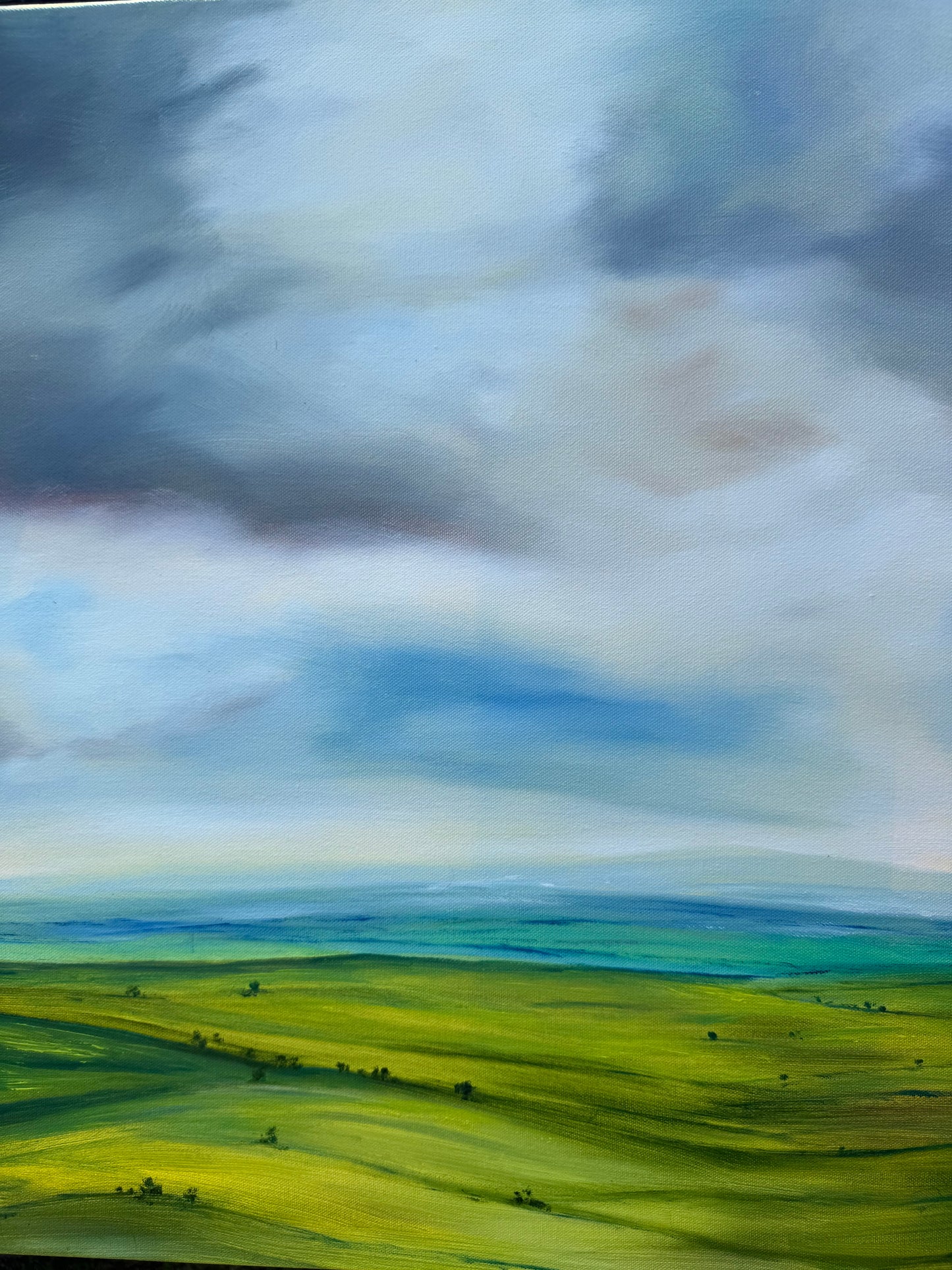 Peace original oil landscape painting of rolling green fields under a moody, dramatic grey and purple storm sky by Caroline Manson